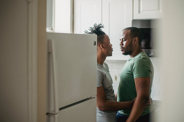 Couple Standing Together In Kitchen