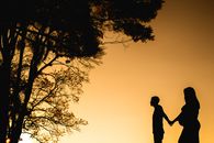 Silhouette of Man Standing Near Tree during Sunset