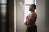 Topless Man in Black Pants Standing in Bathroom