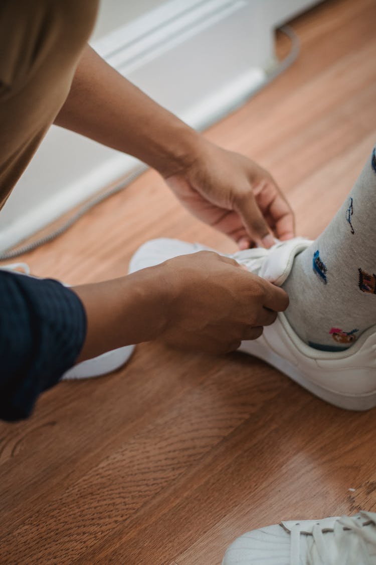 Man Tying His Childs Shoes 