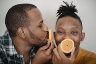 Two Men Playing with Slices of Orange