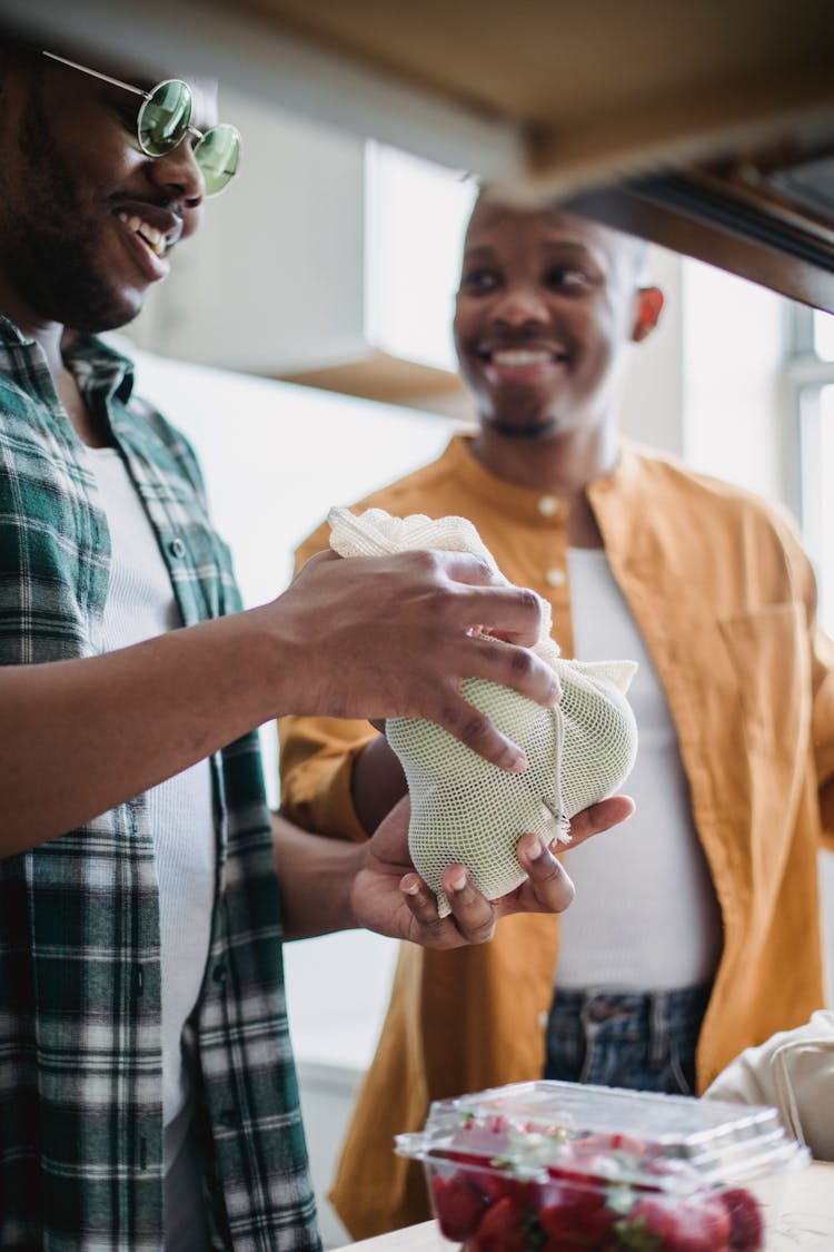 Men Unpacking Groceries In Kitchen