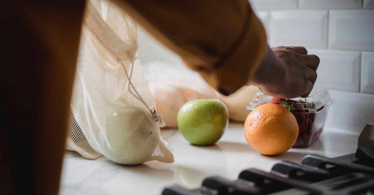 person unpacking groceries with reusable bags and glass containers — lifestyle shot