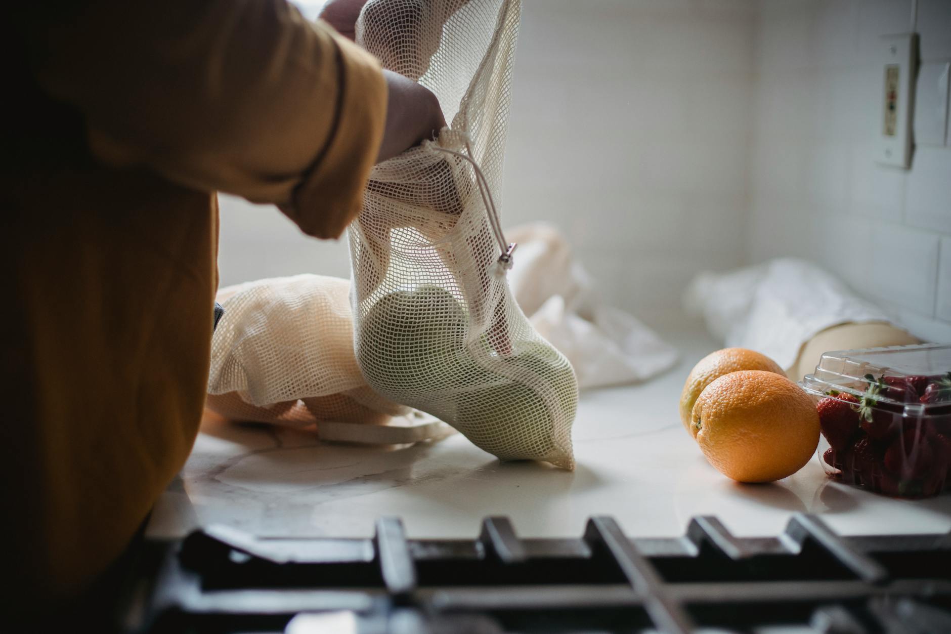 Citrus Fruits In A Mesh Bag On A Kitchen Counter