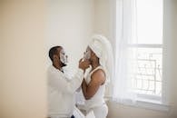 Man in White Tank Top Kissing Woman in White Tank Top