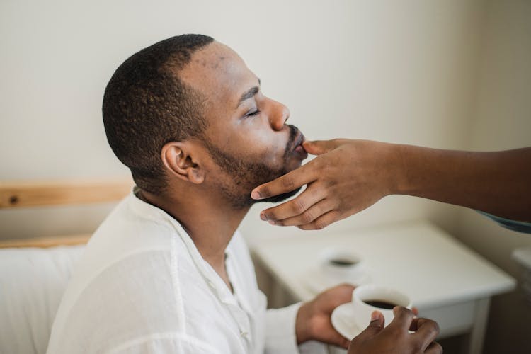 Man Drinking Coffee Kissing Partner Hand