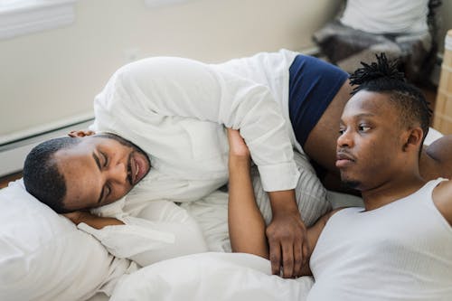 Free Men Lying in Bed while Looking at Each Other Stock Photo
