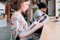 Woman in White Red and Blue Floral Shirt Holding White Smartphone