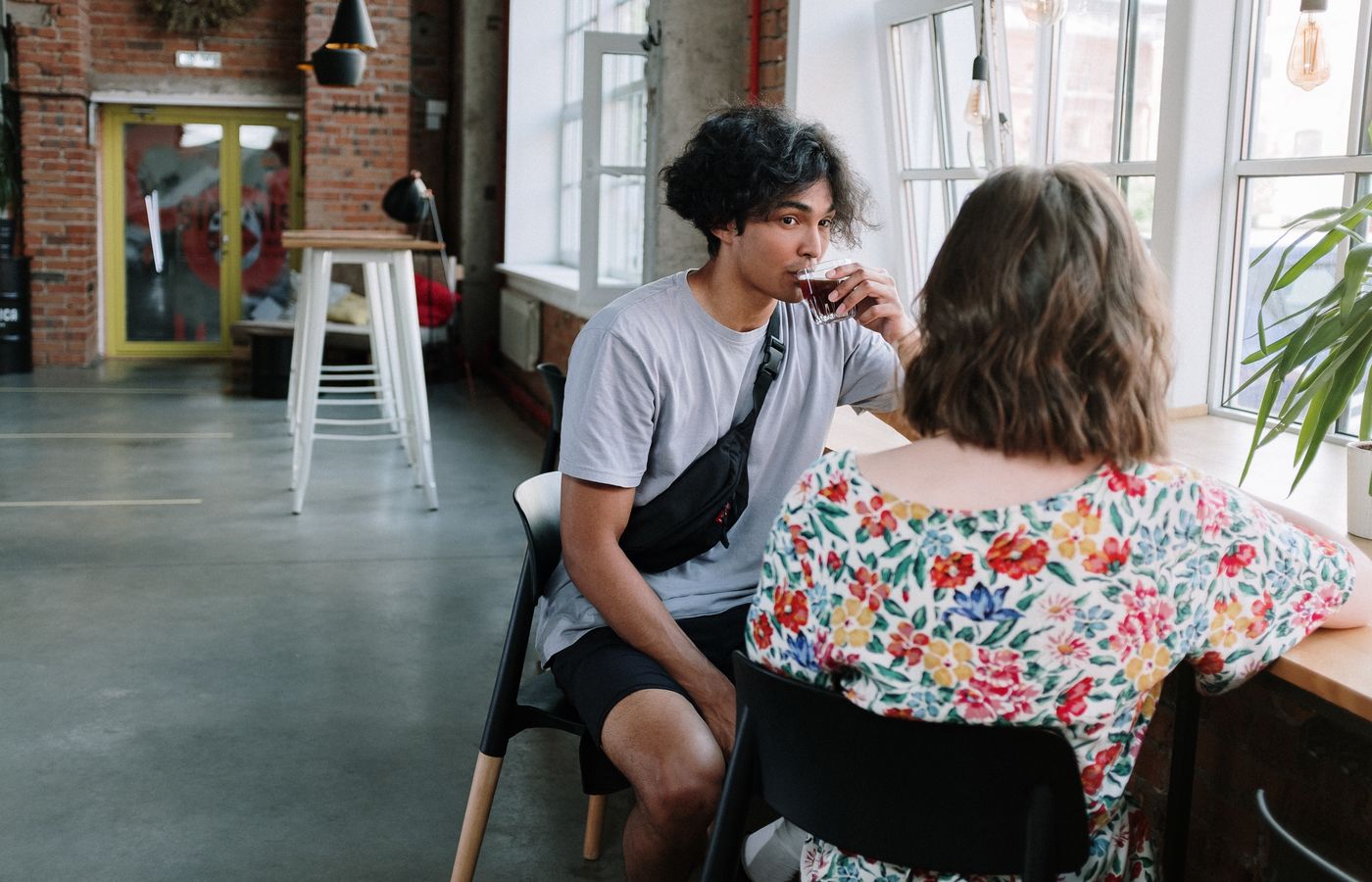 Young adults enjoy a relaxed conversation and coffee in a stylish urban café.