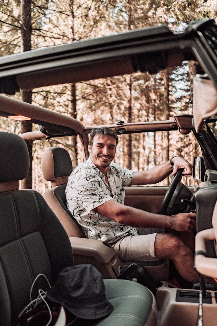A Smiling Man Driving A Jeep 
