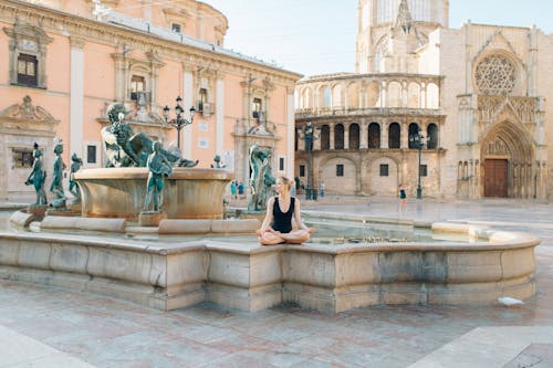 Woman in Black Dress Standing in Front of Fountain
