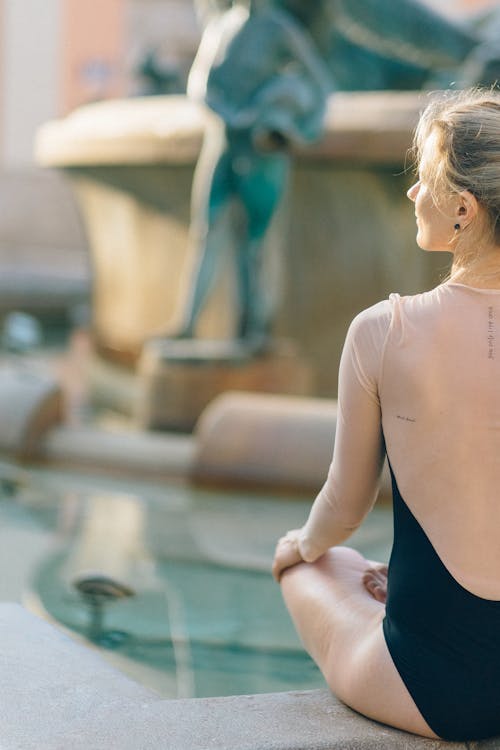 Free Back View of a Woman Meditating while Sitting Stock Photo