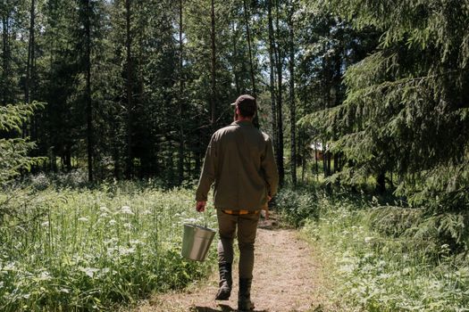 Man in Green Jacket and Brown Pants Walking on Forest
