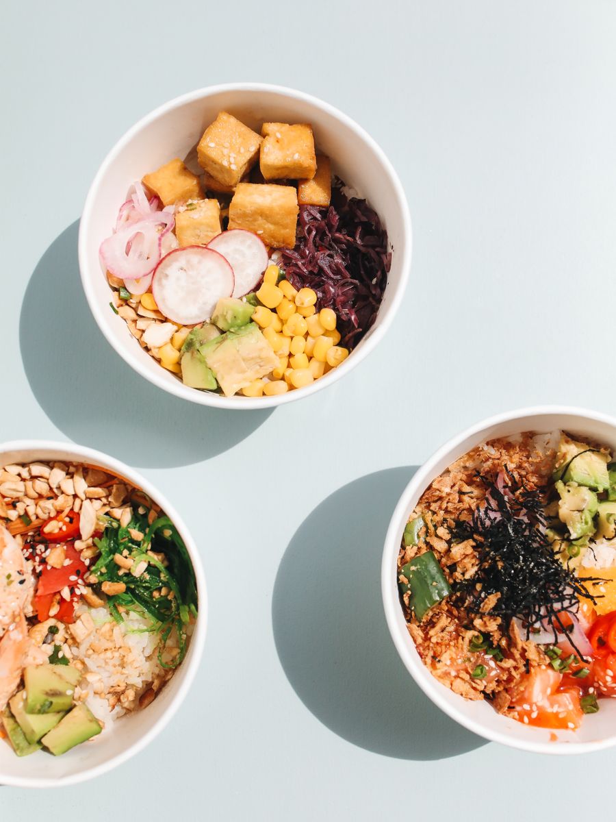 Tres poke bowls coloridos con palta, choclo y tofu.