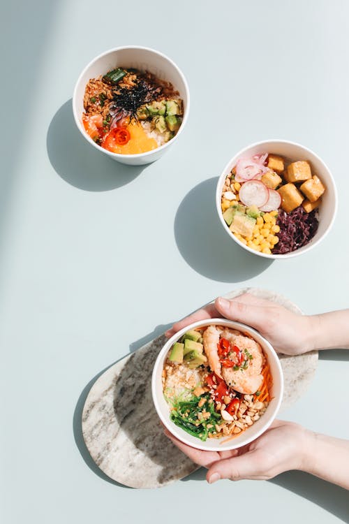 Overhead Shot of a Person's Hands Holding a Poke Bowl