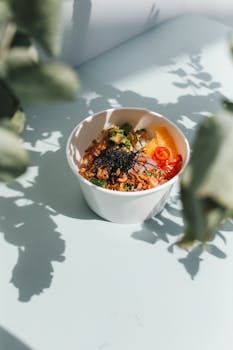 Vibrant Hawaiian poke bowl with fresh ingredients and seaweed garnish in sunlight.