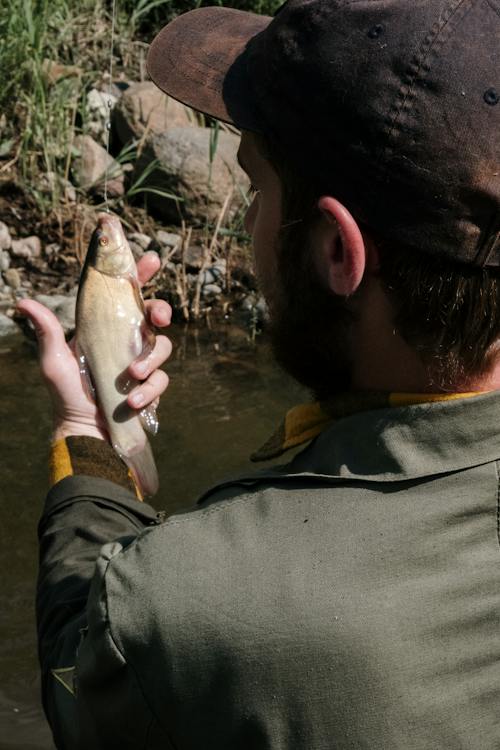 Man in Black Jacket Holding Fish