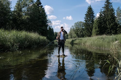 Woman in Blue Jacket and Black Pants Walking on River