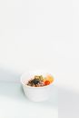 Minimalist photo of a healthy poke bowl with fresh ingredients like avocado and salmon.