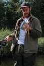 Man in Brown Coat Holding Black and White Camera