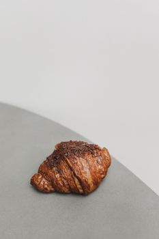 极简主义风格的桌子上，巧克力羊角面包的特写镜头，非常适合展现早餐的视觉效果