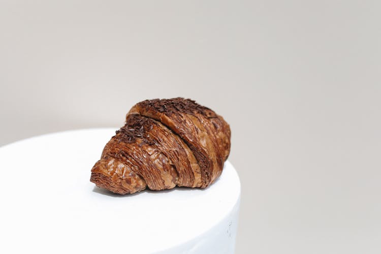 Close-Up Photo Of A Chocolate Croissant On A White Surface