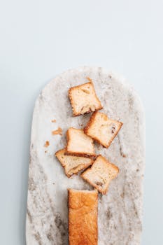 Overhead shot of sliced bread on a marble board, perfect for food presentations.