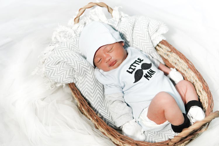 Photograph Of A Newborn Baby In A Basket