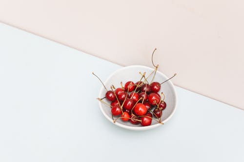 Red Cherries with Stems on a White Bowl