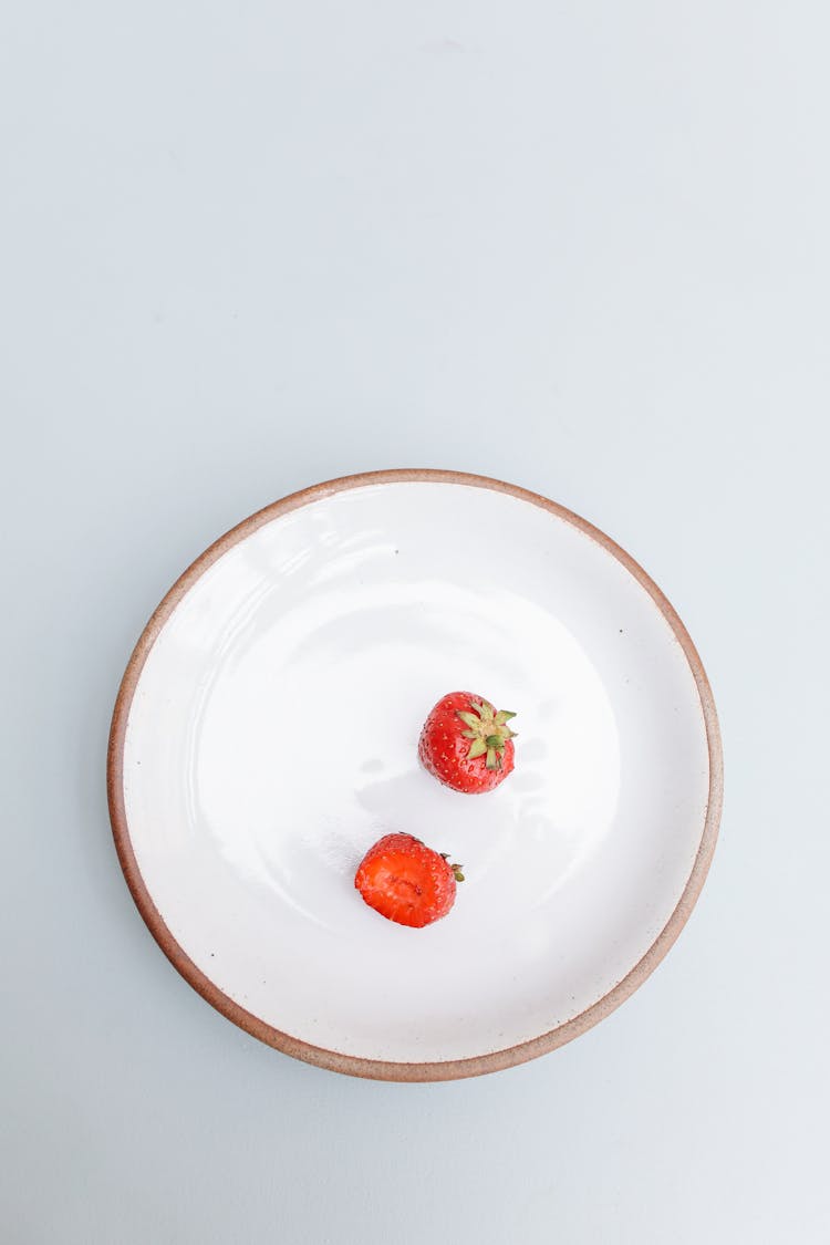 A Bitten Strawberry On A Bowl