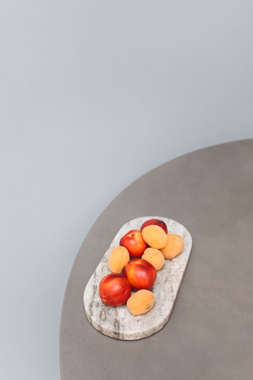 Free A minimalist display of fresh apricots and apples on a marble tray, perfect for healthy eating concepts. Stock Photo