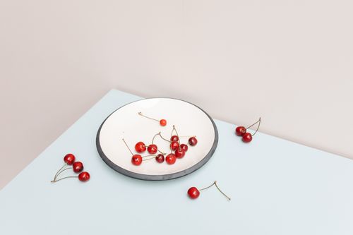 Free Simple and elegant arrangement of cherries on a plate with a minimalist style. Stock Photo