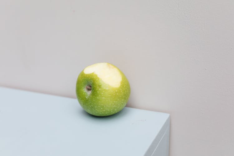 Close-Up Photo Of A Green Apple With A Bite