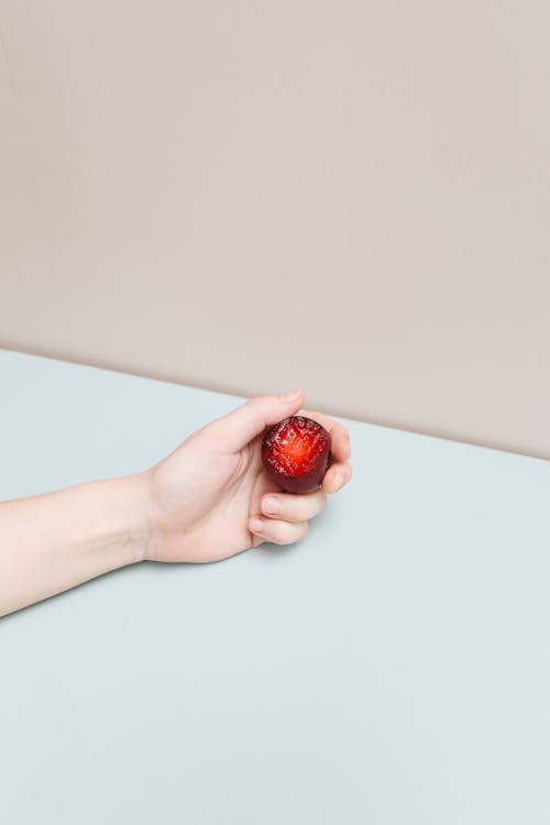 Free Person Holding a Plum Fruit  Stock Photo