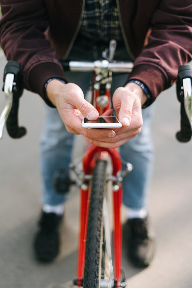 Photo Of A Cyclist Using His Mobile Phone