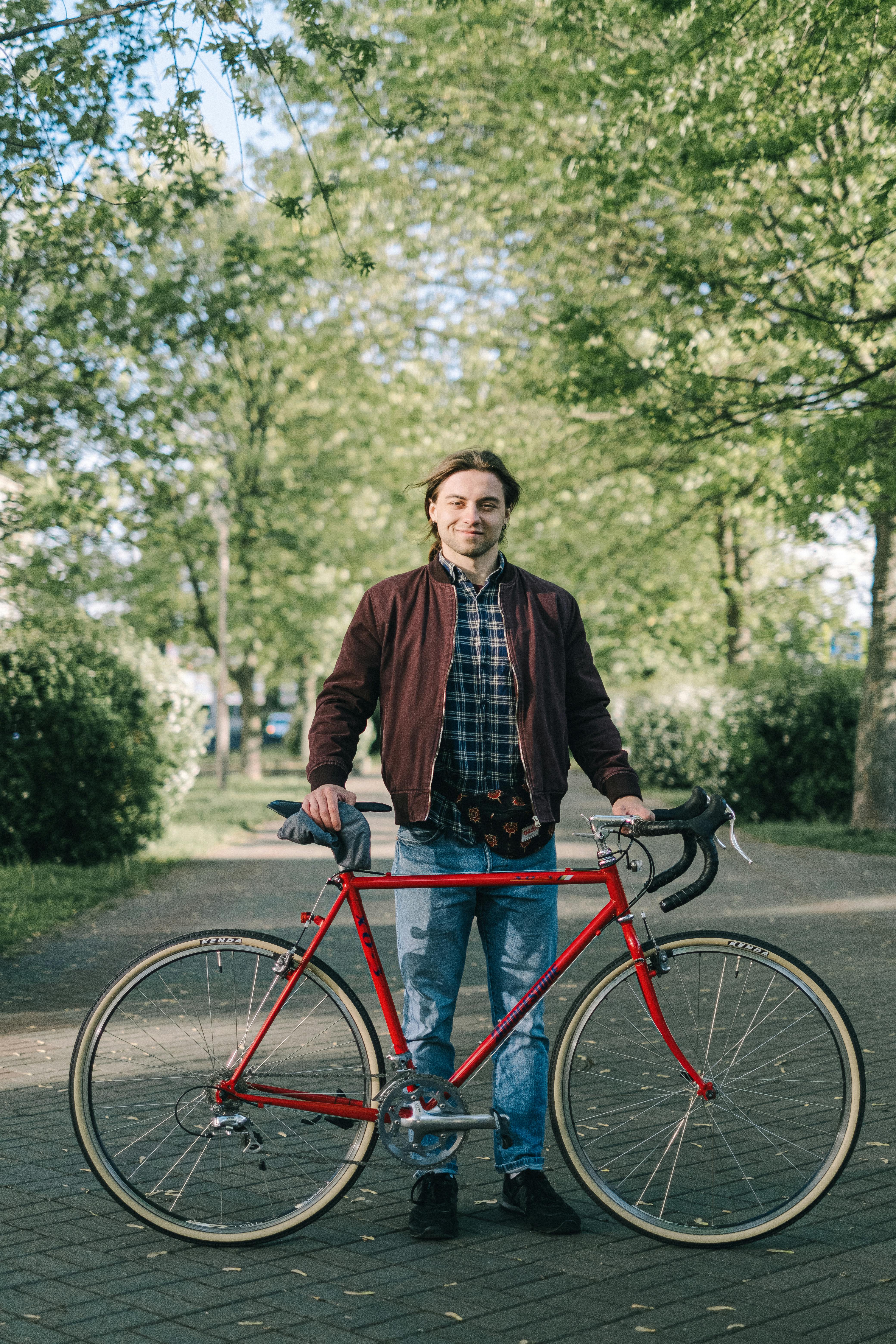 一个人在风景秀丽的公园里，骑着红色自行车，享受户外活动