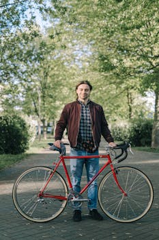 一个人在风景秀丽的公园里，骑着红色自行车，享受户外活动