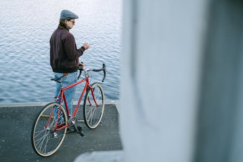 Kostnadsfri bild av använder sig av, brun jacka, cykel