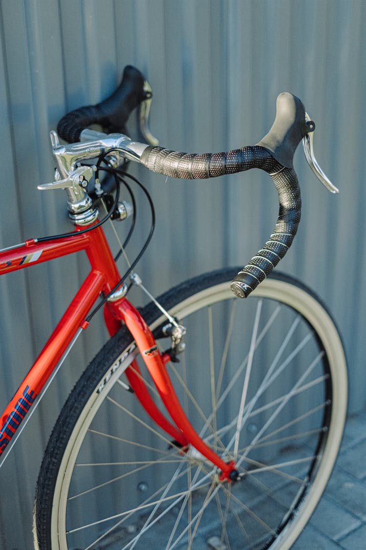 Red And Black Bicycle On Gray Metal Wall Panel