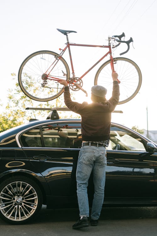Free Person Putting the Bicycle on the Car Roof  Stock Photo