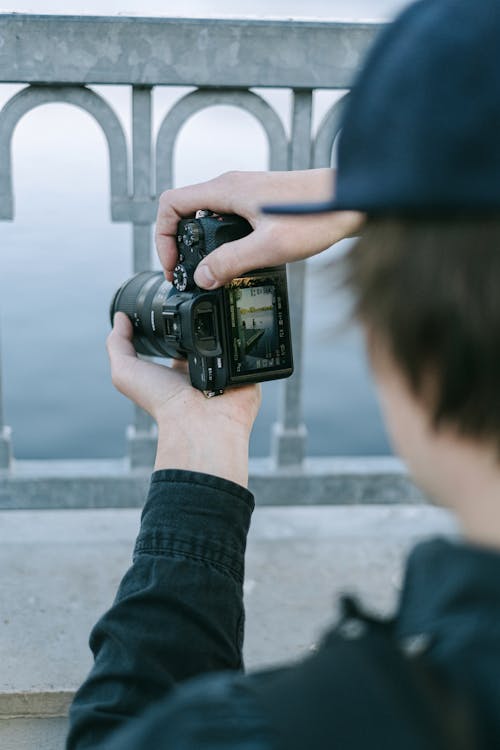 Photo of a Person Using a Black Camera