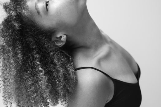 Grayscale Photo of a Woman with Curly Hair Looking Up
