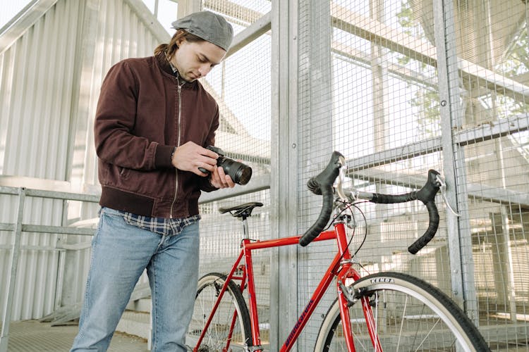 A Looking At A Camera While Standing Next To A Bicycle