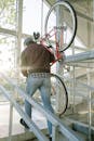 Back View of a Man Carrying a Bicycle