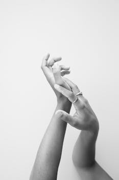 一只戴着戒指的手的灰度图像，强调优雅与简约