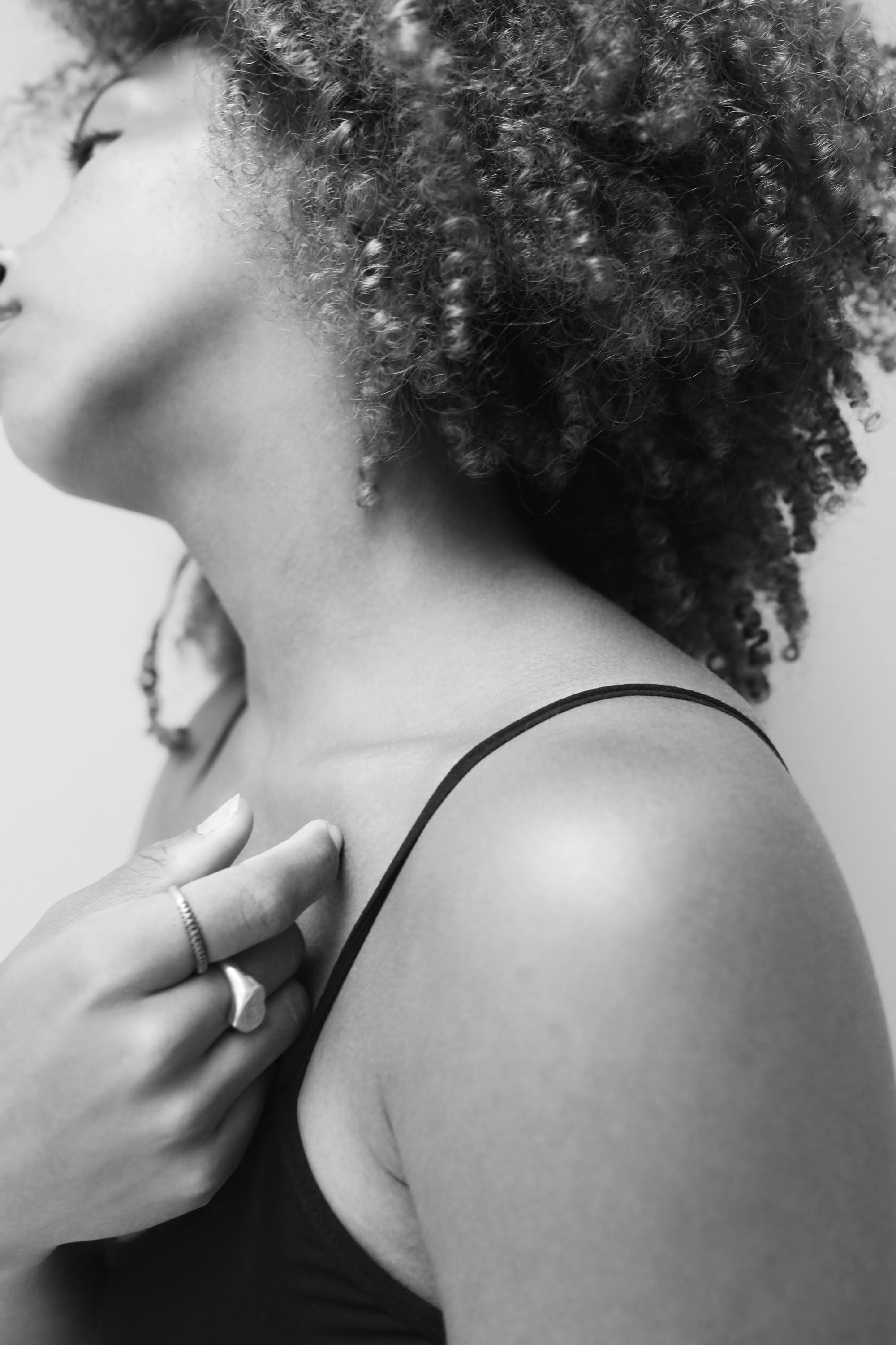 Elegant black and white portrait featuring a woman with curly hair, showcasing emotion and texture.
