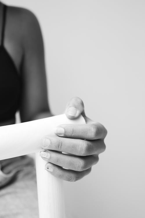 Close-up of a Person's Hand Holding the Top Rail of a Chair