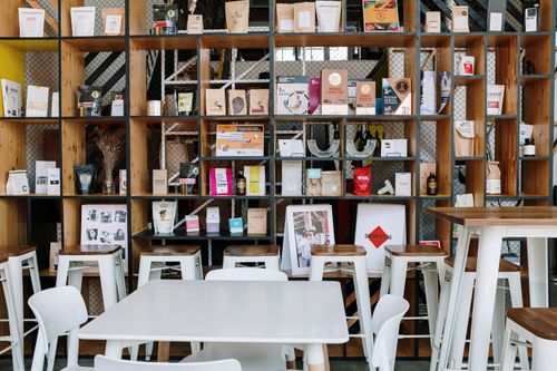 Free Modern café interior featuring stylish shelving with products and decor, perfect for cozy gatherings. Stock Photo