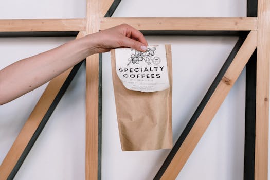 A hand holds a specialty coffee package, offering a minimalist and artisanal feel.