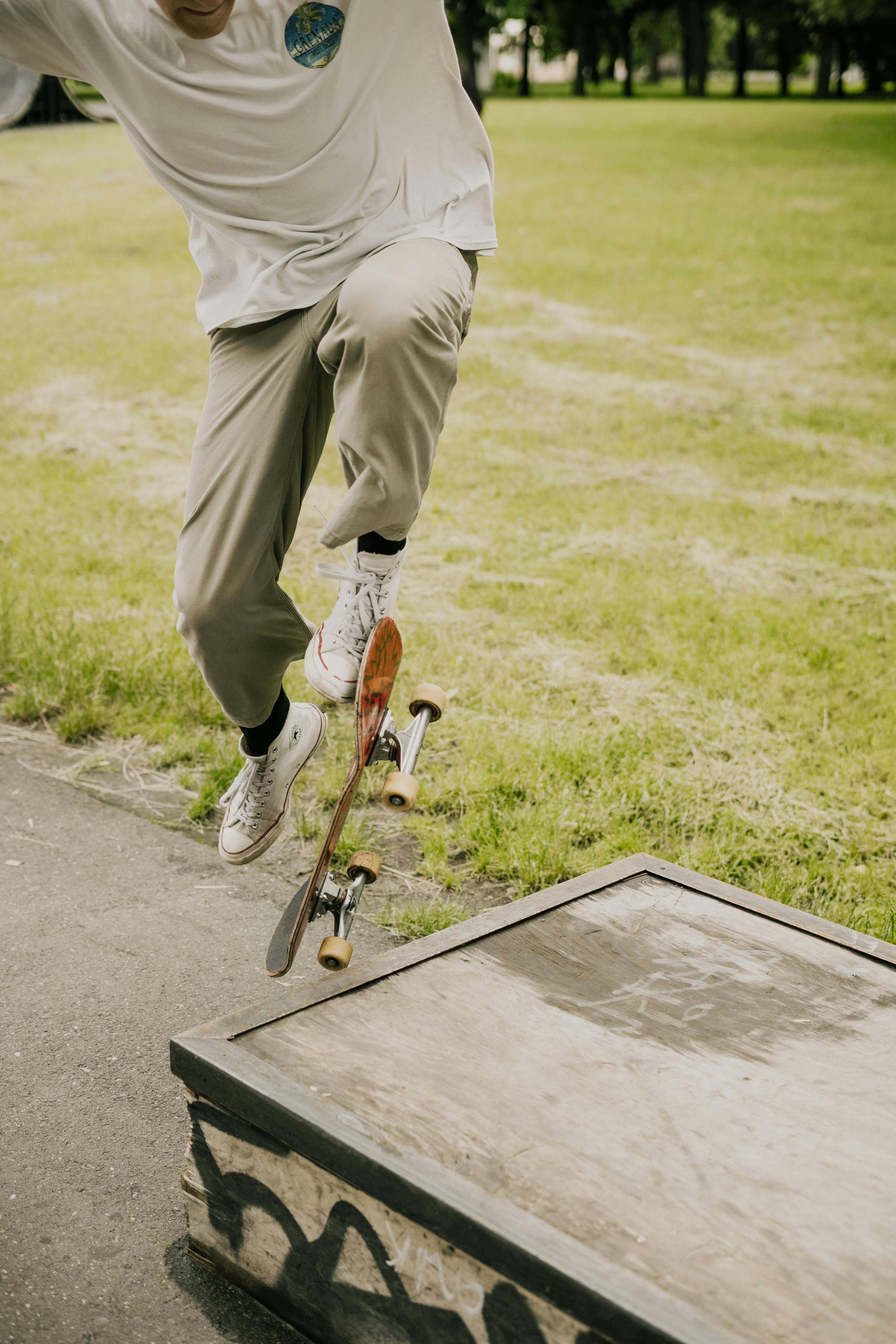 阳光明媚的一天，一名滑板者在滑板公园表演了一个激动人心的空中动作